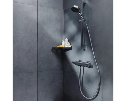 Dusche mit Duschkopf, Brauseschlauch und Ablage für Duschutensilien an der Wand