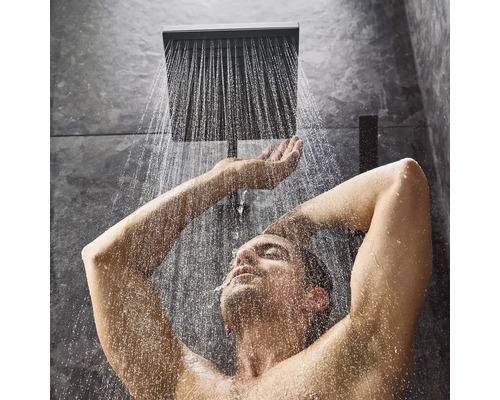 Mann unter einer Regendusche im Badezimmer