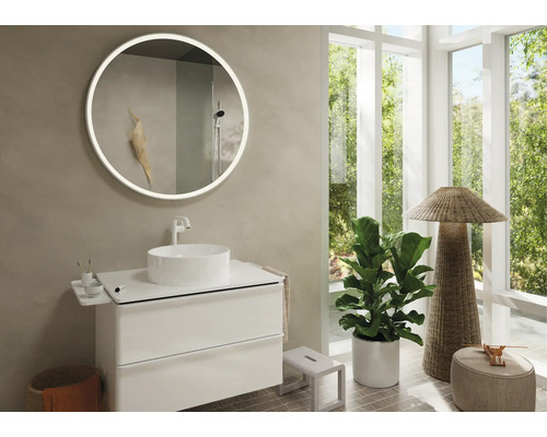 Helles Badezimmer mit rundem Spiegel, Waschbecken auf Unterschrank und Fensterfront