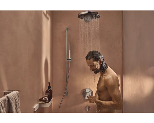 Mann unter einer Regendusche im Badezimmer mit Duschkopf und Handbrause.