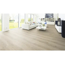 Salon lumineux avec sol stratifié, canapé, table et baie vitrée