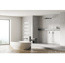 Salle de bains lumineuse avec baignoire îlot, sèche-serviettes et douche