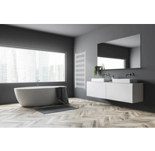 Helles Badezimmer mit Badewanne, Waschtisch mit zwei Waschbecken, Spiegel und Heizkörper