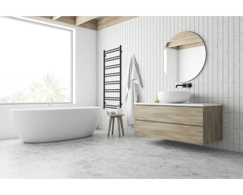 Helles Badezimmer mit freistehender Badewanne, Waschtisch mit rundem Spiegel und Handtuchwärmer