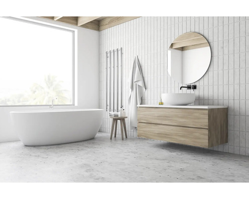 Salle de bain lumineuse avec baignoire îlot, meuble-lavabo avec miroir rond et sèche-serviettes