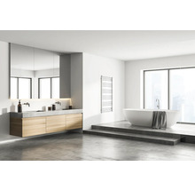 Helles Badezimmer mit Waschtisch, Spiegel, Badewanne und Handtuchwärmer