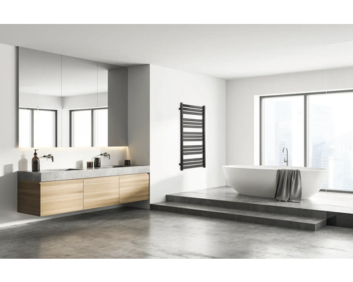 Helles Badezimmer mit Waschtisch, Spiegel, Heizkörper und freistehender Badewanne.