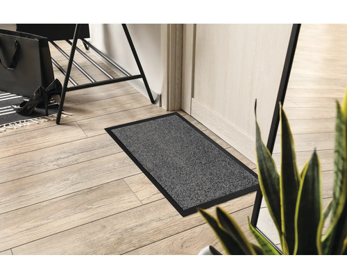 Paillasson gris avec bordure noire dans l''entrée.