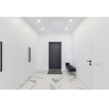 Couloir lumineux avec armoire, porte, banc et sol en marbre