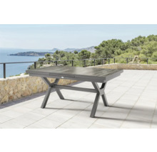 Table de jardin grise avec piètement en X sur une terrasse avec vue sur la mer