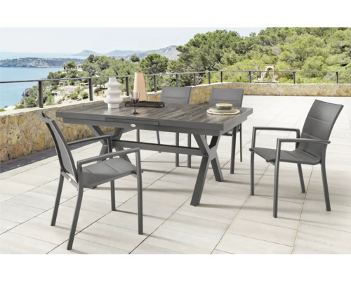 Scène d''extérieur avec table à manger et chaises sur une terrasse avec vue sur la mer
