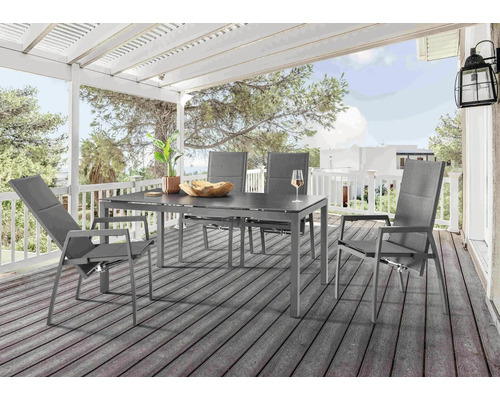 Scène de jardin avec table à manger et quatre chaises sur une terrasse