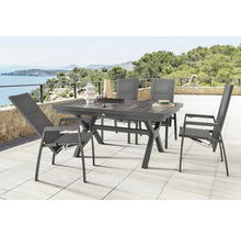 Table de jardin avec chaises sur une terrasse avec vue sur la mer.