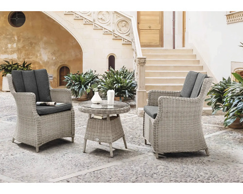 Fauteuil de jardin Destiny Luna Malaga 2 places 3 pces vintage blanc, 2 fauteuils + table, rotin synthétique + aluminium, y compris galettes d'assise Ensemble de mobilier de jardin composé de deux fauteuils en rotin et d''une table avec plateau en verre sur une terrasse.