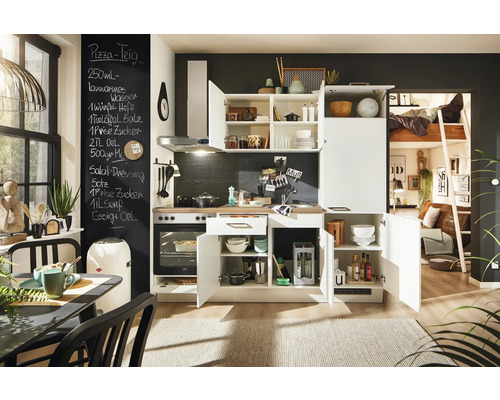 Cuisine compacte avec placards blancs, plan de travail et plaque de cuisson, ainsi qu''un coin repas