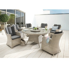 Ensemble de meubles de jardin avec table ronde et six chaises en osier avec coussins sur une terrasse