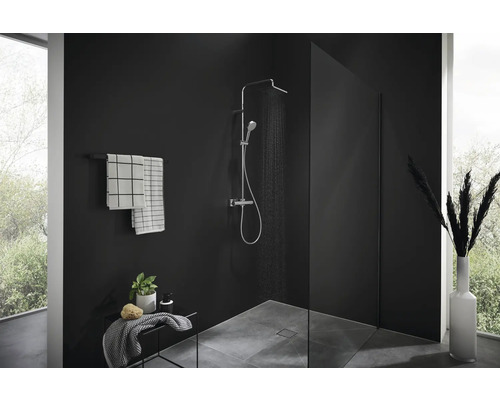 Duschbereich mit Duscharmatur, Handtüchern und Dekoration in einem modern gestalteten Badezimmer