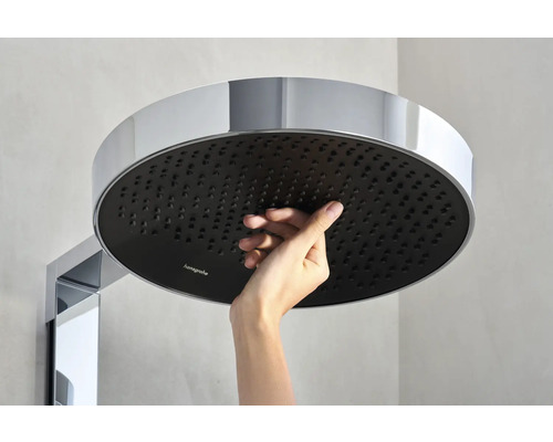 Une main touche une douche de tête ronde Hansgrohe
