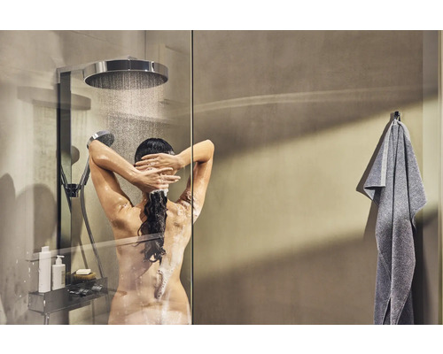 Femme sous la douche avec douche de tête et douchette, ainsi qu''étagère de douche et serviette