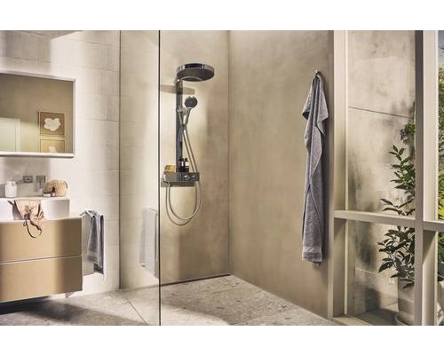 Salle de bains lumineuse avec douche, lavabo et serviettes