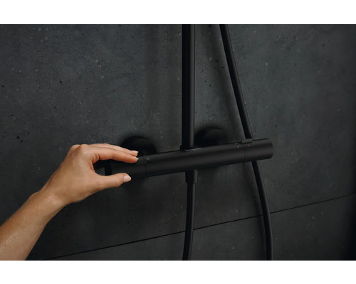 Photo d''une main actionnant un thermostat de douche noir Hansgrohe