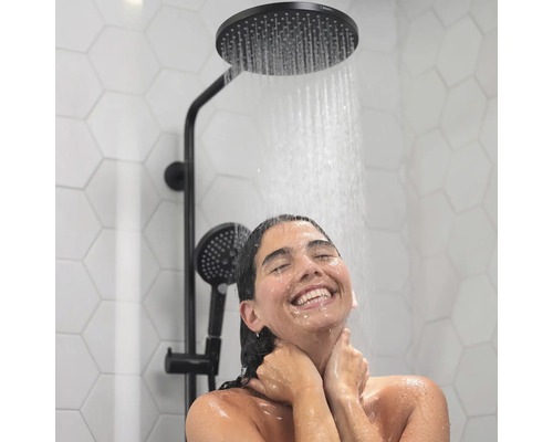 Frau unter einer Duscharmatur mit Kopf- und Handbrause.