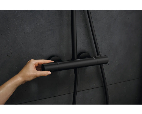 Photo d''une main actionnant un thermostat de douche pour régler la température.