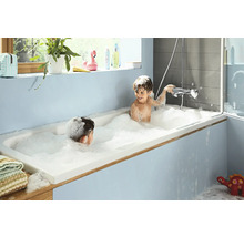Deux enfants jouent avec de la mousse de bain dans une baignoire dans une salle de bains.