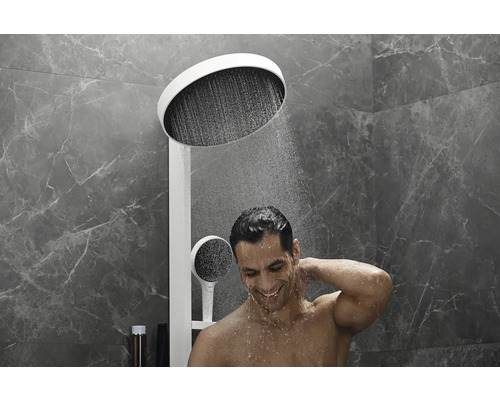 Homme sous une douche de tête avec douchette dans la salle de bain