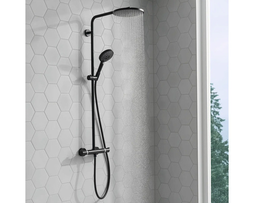 Duschsystem mit Kopf- und Handbrause vor einer sechseckigen, gefliesten Wand