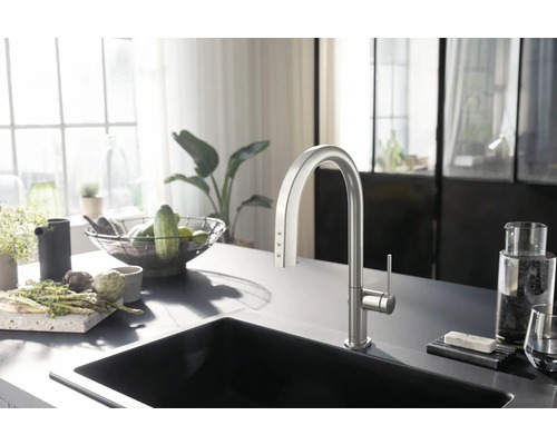 Küchenszene mit Spüle, Armatur und Lebensmitteln auf der Arbeitsfläche.