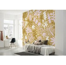 Chambre avec papier peint à motifs, lit, bureau et chaise.