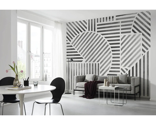 Salon avec papier peint graphique, canapé, table et chaises