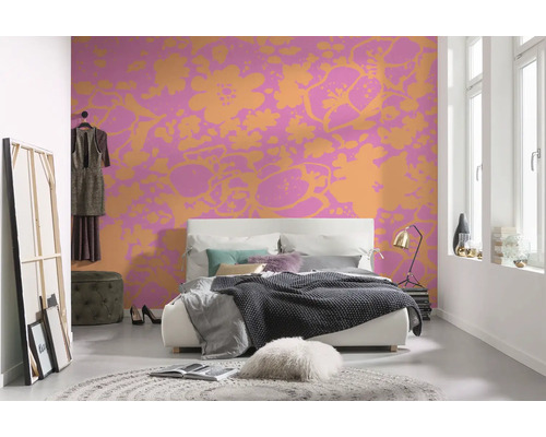 Schlafzimmer mit Doppelbett, Teppich und floral gemusterter Tapete