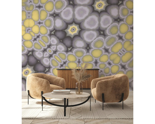 Salon avec deux fauteuils, table basse, buffet et papier peint à motif abstrait