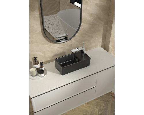 Vasque à poser noire avec robinet sur un meuble-lavabo avec miroir