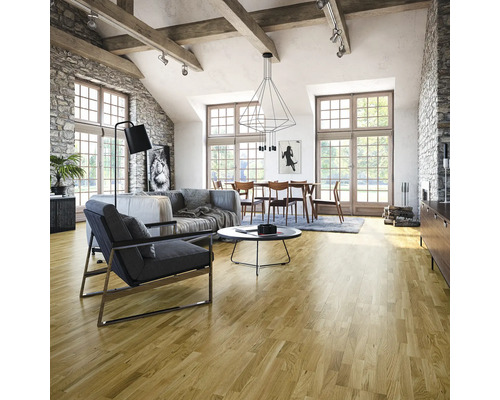 Espace de vie lumineux avec parquet, canapé, fauteuil et table à manger sous une suspension moderne.