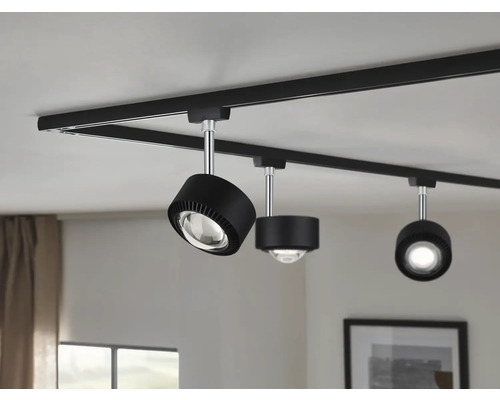 Schwarzes Schienensystem mit drei Strahlern an der Decke.