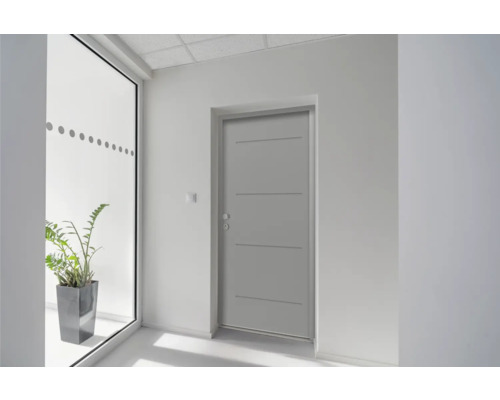 Porte intérieure grise avec trois moulures décoratives horizontales dans un couloir lumineux