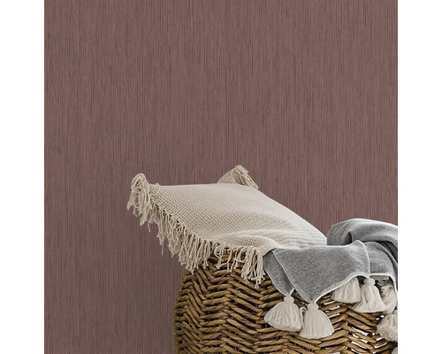 Nahaufnahme einer Wand mit Tapete, einem Kissen und einer Decke in einem Korb