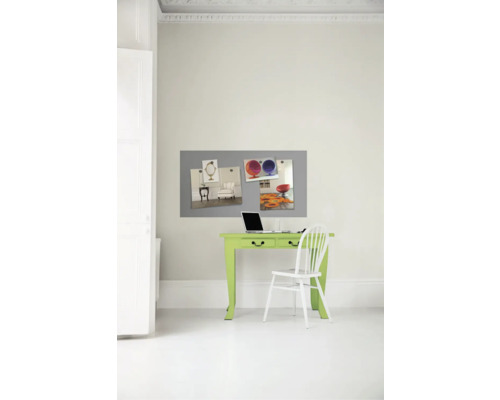 Arbeitszimmer mit grünem Schreibtisch, weißem Stuhl, Laptop und grauer Magnettafel an der Wand