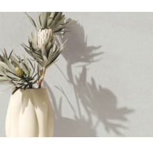 Blumen in Vase vor einer strukturierten Wand