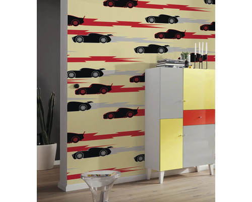 Vue d''une pièce avec un papier peint à motifs avec des voitures, combiné à une armoire colorée.