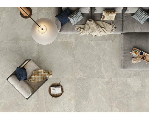 Helle Fliesen mit Marmoroptik in einem Wohnzimmer mit Sofa, Sessel und Lampe von oben