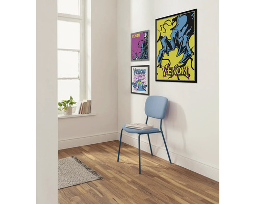 Raumansicht mit drei gerahmten Venom-Postern an der Wand und einem hellblauen Stuhl