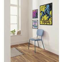 Dekoratives Interieur mit Venom-Postern an der Wand und einem hellblauen Stuhl