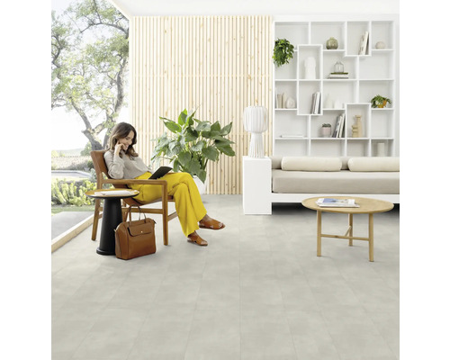 Une femme est assise avec une tablette dans une pièce lumineuse avec un sol design