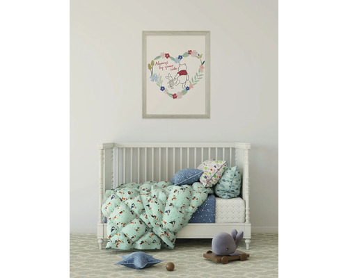 Kinderzimmer mit Gitterbett, Bettwäsche und einem gerahmten Winnie Puh Bild an der Wand