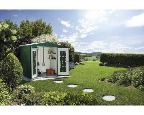 Abri de jardin en métal avec portes ouvertes et outils de jardin dans un espace extérieur verdoyant