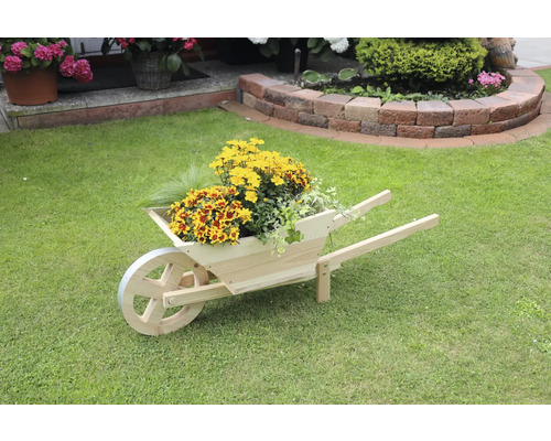 Holzschubkarre mit gelben und roten Blumen auf Rasen